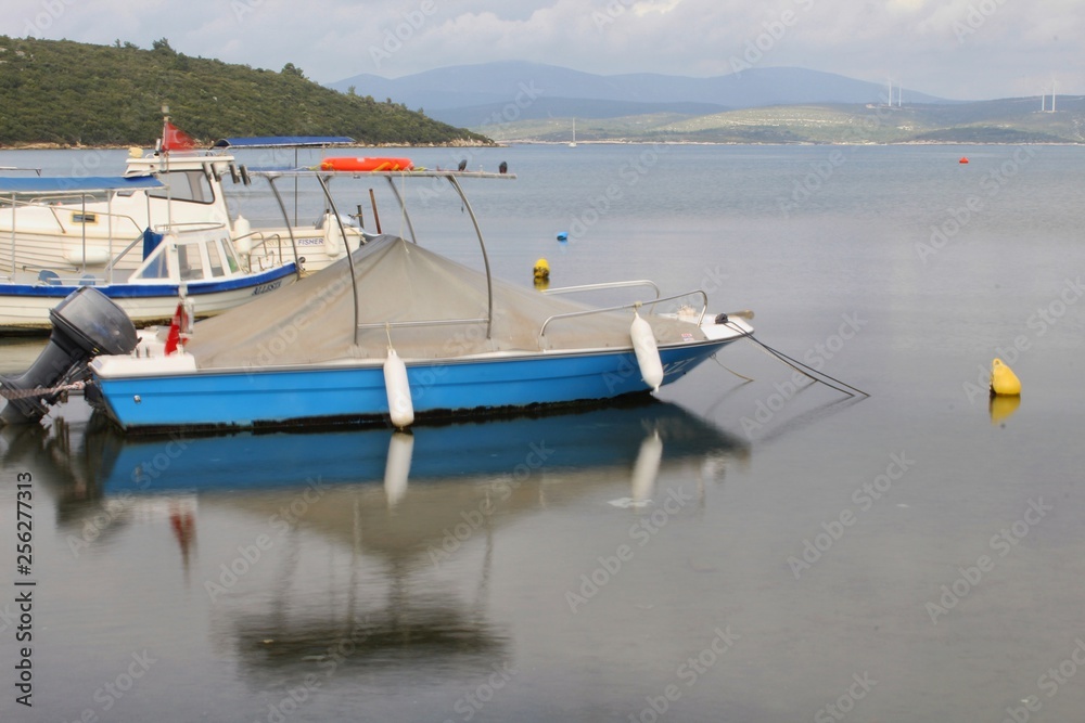 Fototapeta premium A blue boat on the sea(taken with long exposure)