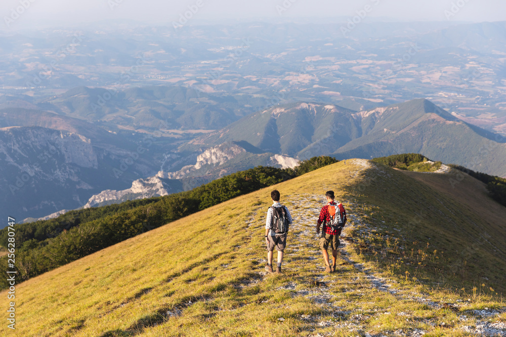 Italy, Monte Nerone, two men hiking on top of a mountain in summer