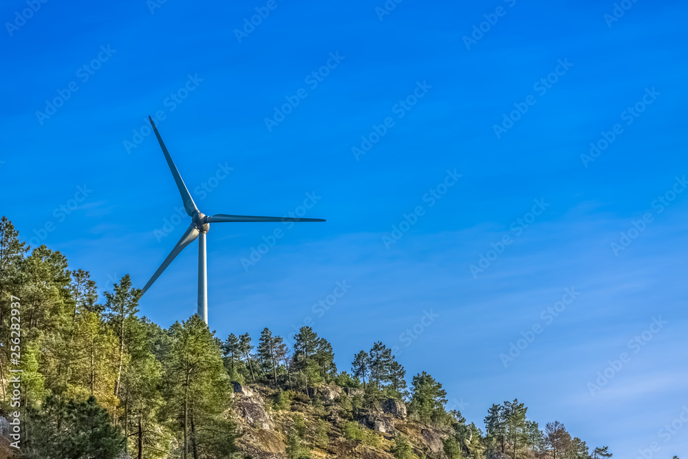 View of a wind turbine on top of mountains View of a wind turbine on top of mountains