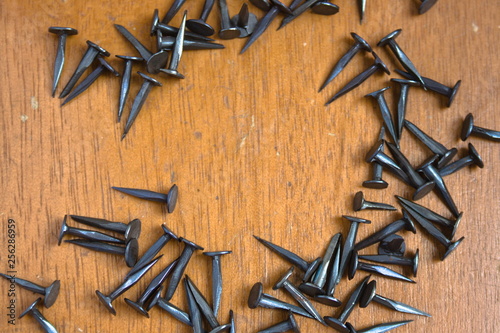 Tacks on wooden background, excellent combination of materials used in carpentry