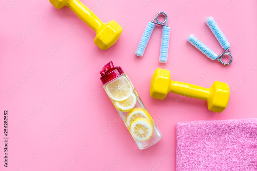 Naklejka premium Fitness background with sport equipment for gym and home on pink background top view copyspace