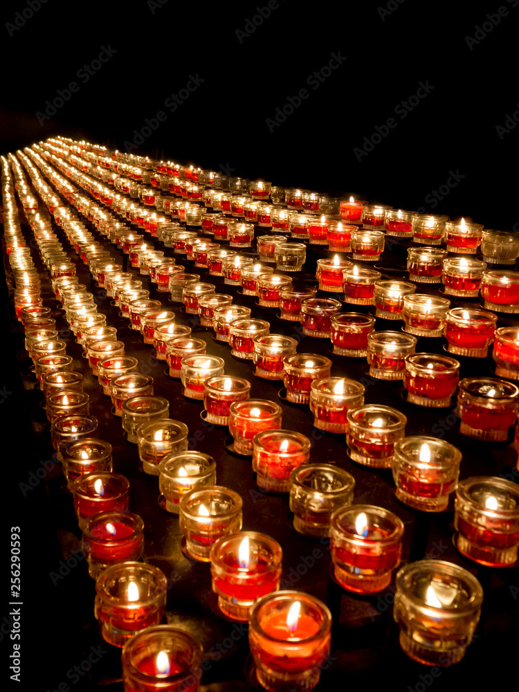 Opferlichter brennen in der Kirche - viele rote Kerzen auf schwarzem  Hintergrund Stock Photo | Adobe Stock