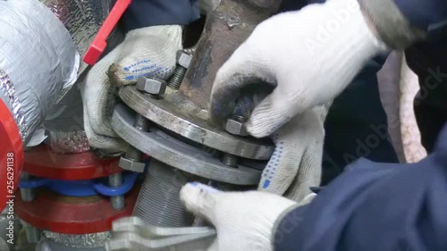 Technicians do water pump repair works. Bolts and nut are locked for pipe connections with water pumps. CloseUp