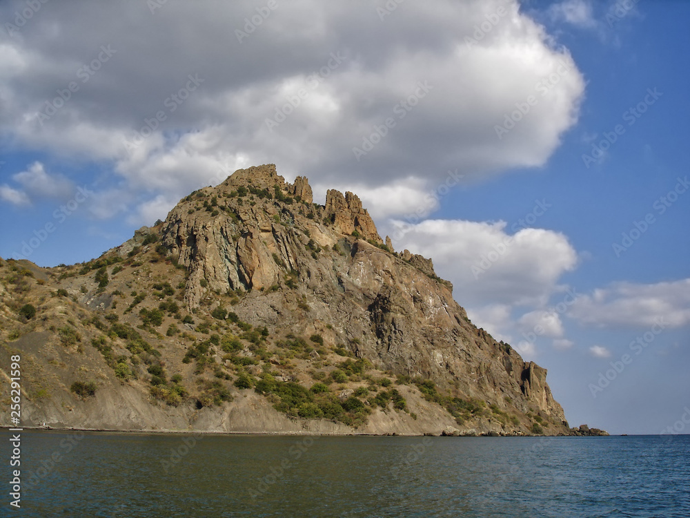 Karadag (Black Mountain) -  extinct volcano in Crimea, famous for its bizarre rock formations. View from the sea in sunny day of golden autumn