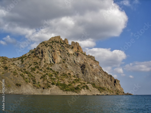 Karadag (Black Mountain) - extinct volcano in Crimea, famous for its bizarre rock formations. View from the sea in sunny day of golden autumn