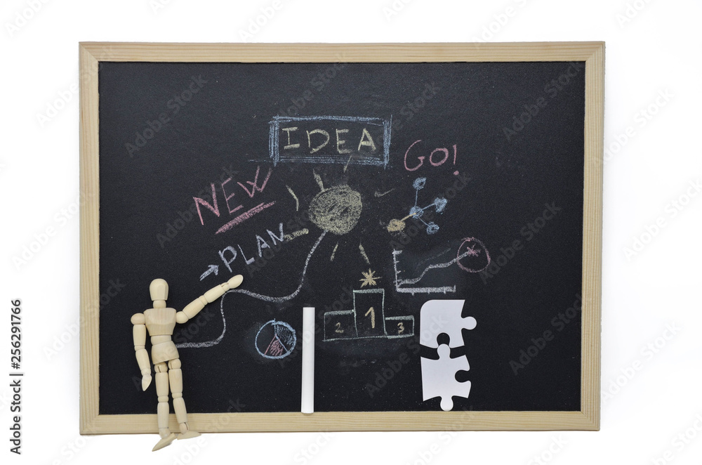 Wooden doll pointing to a blackboard, New ideas. Entrepreneurial concept, new ideas, innovation. Blackboard written with chalk Wooden doll pointing to a blackboard, New ideas. Entrepreneurial concept, new ideas, innovation. Blackboard written with chalk