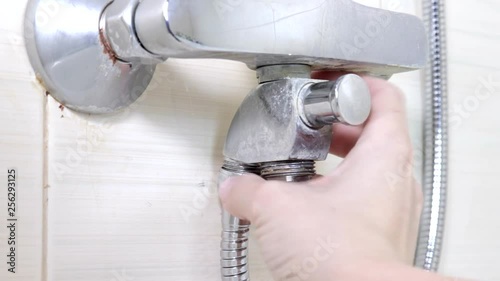 Bathtub faucet reparing, tightening the nut on a new hose instead of leaky shower hose, plumbing repairs and DIY concept