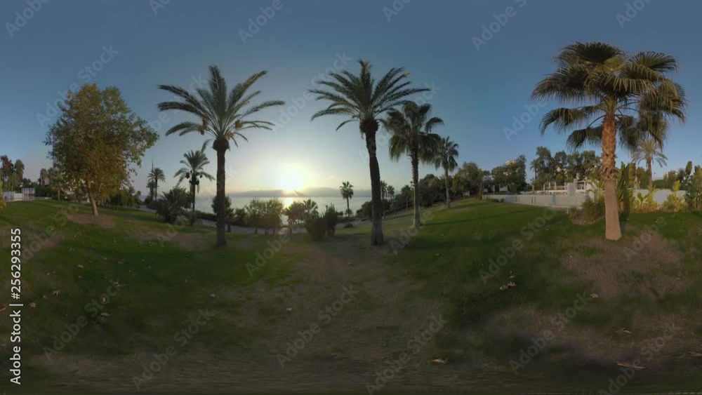 360 VR video. Resort area on Antalya coast, Turkey. Scene with greenspace, outdoor swimming pool, sea and sun setting behind the mountains 360 VR video. Resort area on Antalya coast, Turkey. Scene with greenspace, outdoor swimming pool, sea and sun setting behind the mountains
