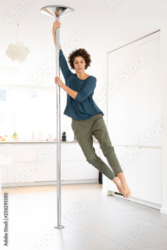 Fototapeta Naklejka Na Ścianę i Meble -  Woman doing pole dance at home