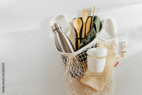 Mesh market bag with bamboo cutlery, reusable coffee mug  and  water bottle. Sustainable lifestyle.  Plastic free concept. photo
