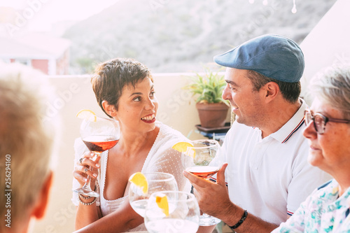 Bright image of caucasian cheerful happy couple having wine cocktail with friends - love and relationship concept for adult man and woman outdoor - people enjoy party together