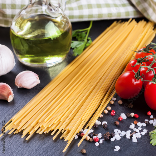 Ingredients for italian pasta on black slate background.