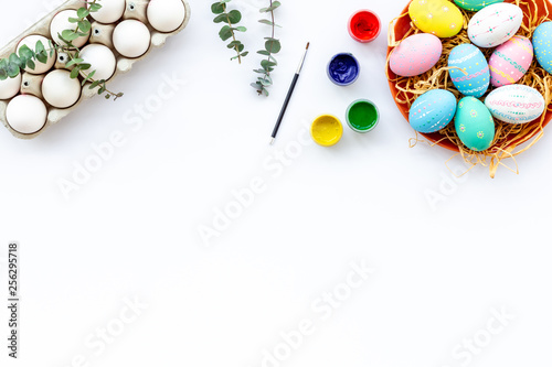 paint eggs for Easter celebration on white background top view copy space