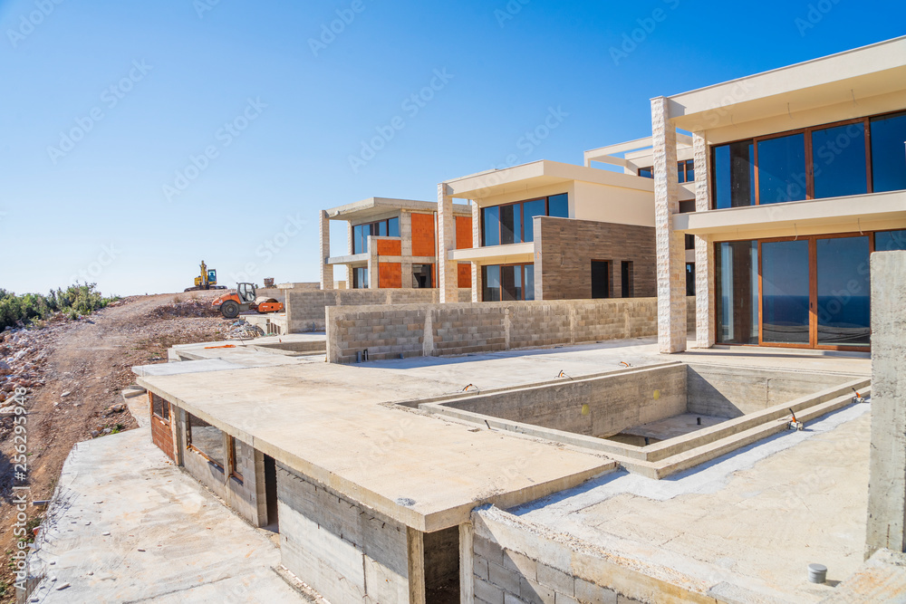Construction site on a sunny spring day, the construction of a complex of villas on the Adriatic coast. View of an unfinished building