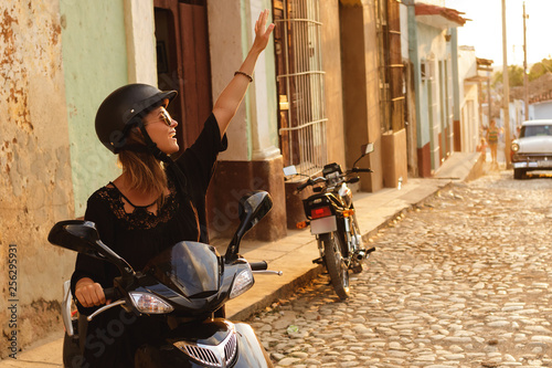 Photography Woman driving scooter by the old city streets