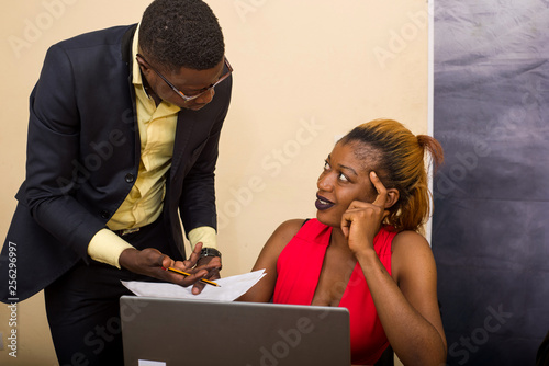 portrait of a young woman and a young man working on laptop in the office
