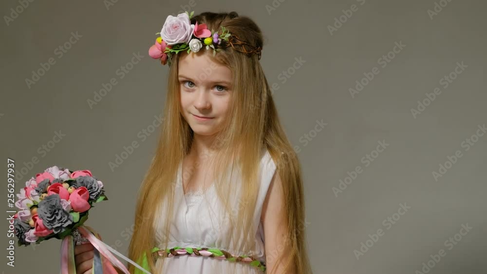 young girl in national costume with a wreath on her head and a bouquet of flowers in her hand with positive emotions young girl in national costume with a wreath on her head and a bouquet of flowers in her hand with positive emotions