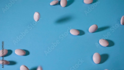 tablets fall on a blue background and roll