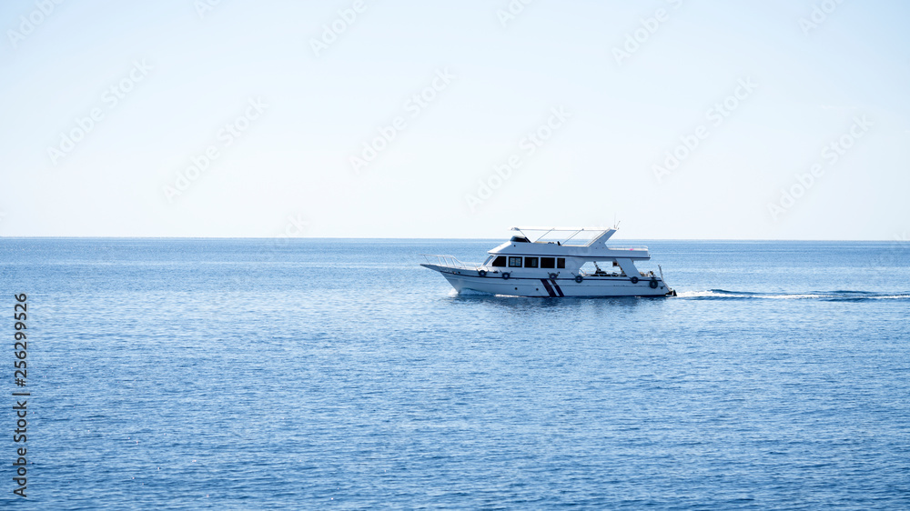 White yacht in the blue sea against a clear blue sky background. White yacht in the blue sea against a clear blue sky background.