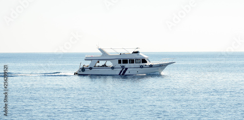 White yacht in the blue sea against a clear blue sky background.