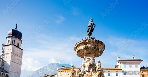 tower of cathedral in Trento and fountain with sculpture of Neptune, Italy