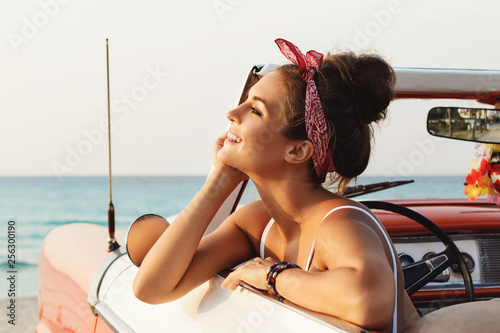 Beautiful and happy woman inside retro cabriolet car