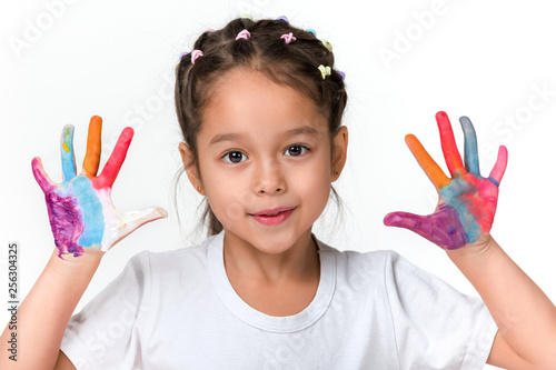 cute little child girl with hands painted in colorful paint isolated on white background.