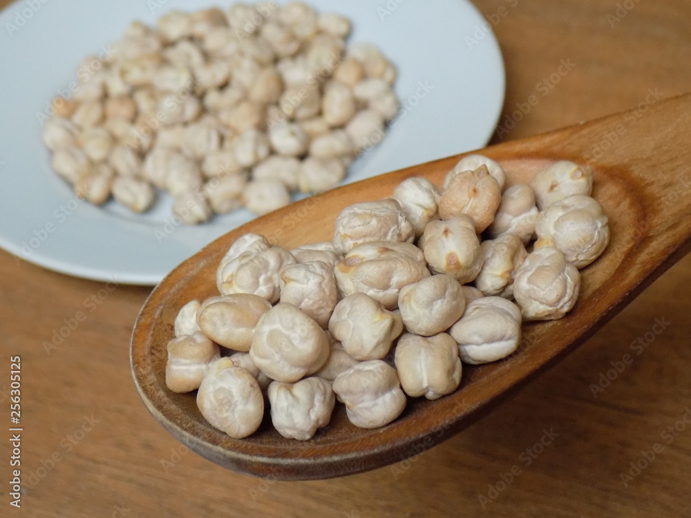 Garbanzos crudos en cuchara de madera Garbanzos crudos en cuchara de madera