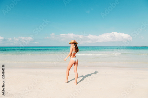 Spain, Mallorca, Rear view of a young woman on holidays standing on the beach photo