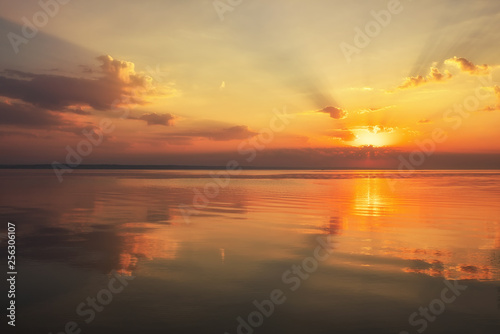 Dramatic sunset sky with clouds over lake. Composition of nature