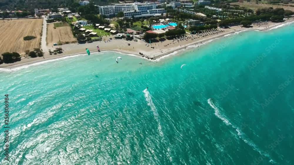 Aerial view of a group of windsurfers sliding on the sea surface near the beach Aerial view of a group of windsurfers sliding on the sea surface near the beach