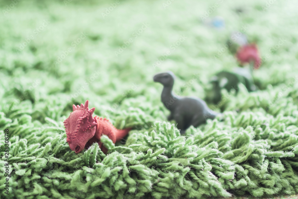 Toy dinosaurs in high grass miniature wild life Toy dinosaurs in high grass miniature wild life