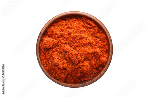 chili powder spice in wooden bowl, isolated on white background. Seasoning top view