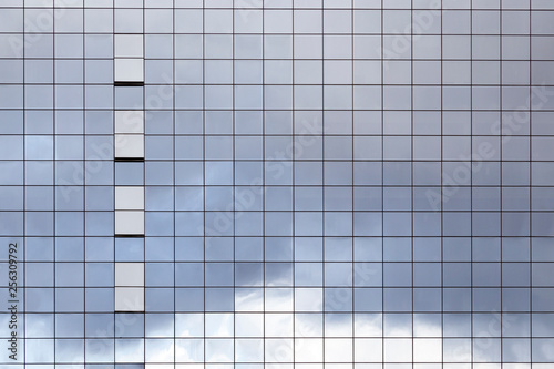 Surface of glass building with the reflection of clouds