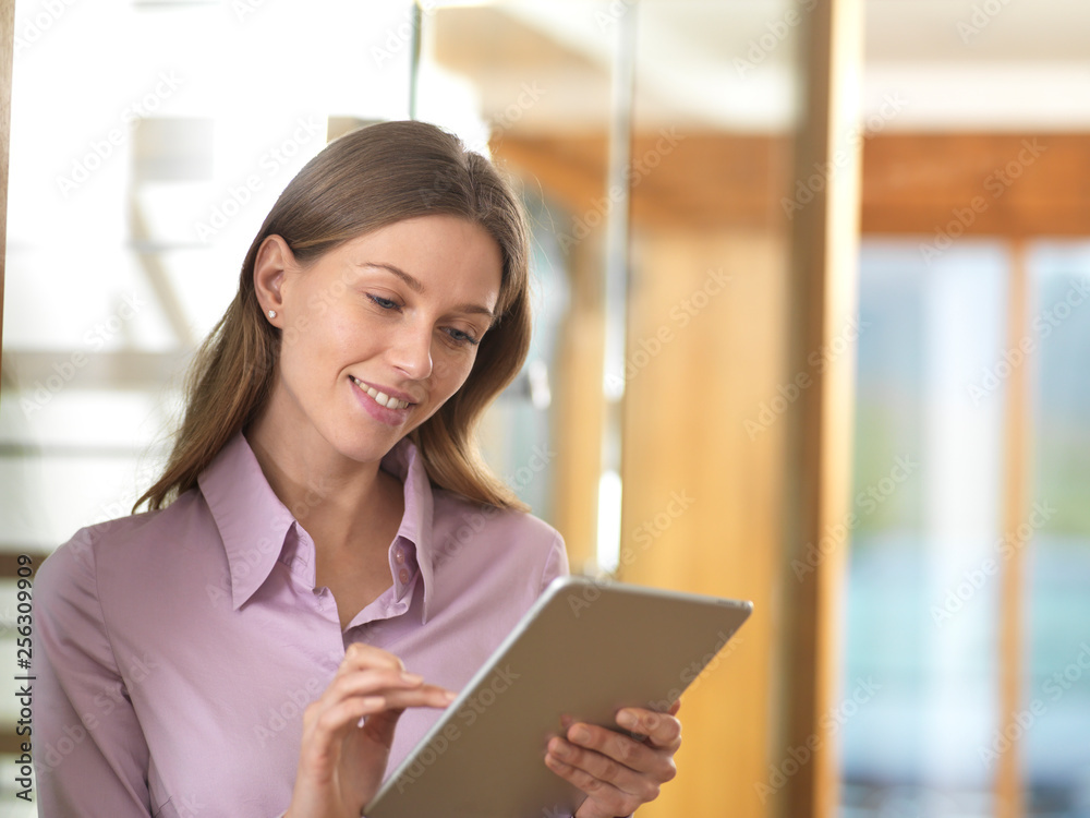 Smiling businesswoman using tablet in office