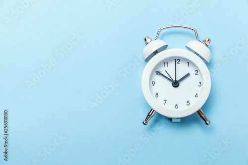Ringing twin bell vintage classic alarm clock Isolated on blue pastel colorful trendy background. Rest hours time of life good morning night wake up awake concept. Flat lay top view copy space