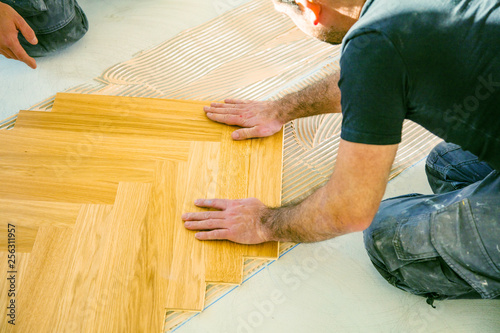 Handwerker bei der arbeit, fischgrät parkett verlegen  photo