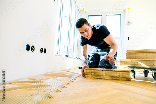 Handwerker bei der arbeit, fischgrät parkett verlegen  photo