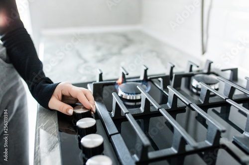 Foto woman hand adjusting gas burning from a kitchen gas stove