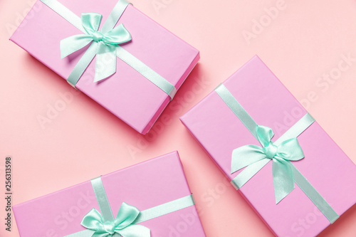 Christmas New Year birthday valentine celebration present romantic concept. Three small gift boxes wrapped pink paper isolated on pink pastel colorful trendy background. Flat lay top view copy space