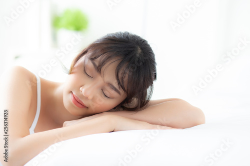 Lifestyle beautiful portrait young asian woman relax lying sleep and smile while wake up with sunrise at morning  girl with happy and fun in the bedroom  health and wellness concept.