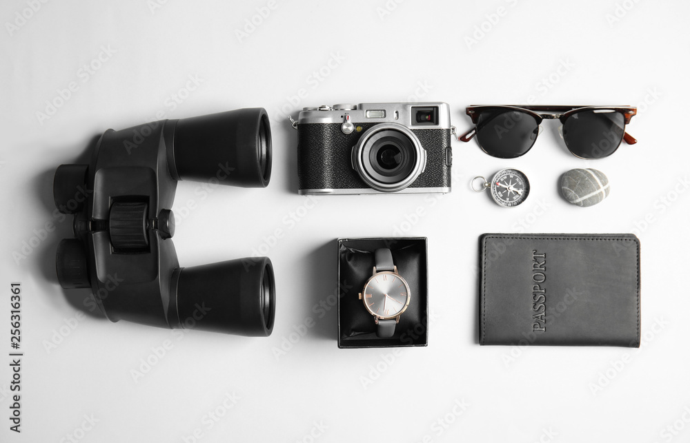 Flat lay composition with camera and binoculars on white background. Travel agency
