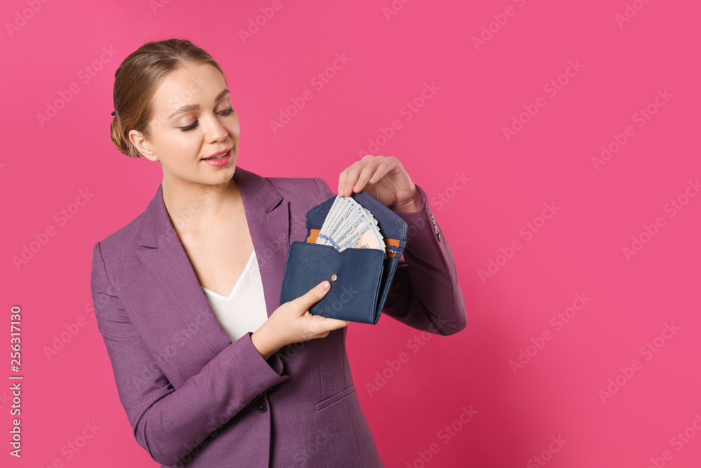 Happy young businesswoman with wallet full of money on color background. Space for text Happy young businesswoman with wallet full of money on color background. Space for text
