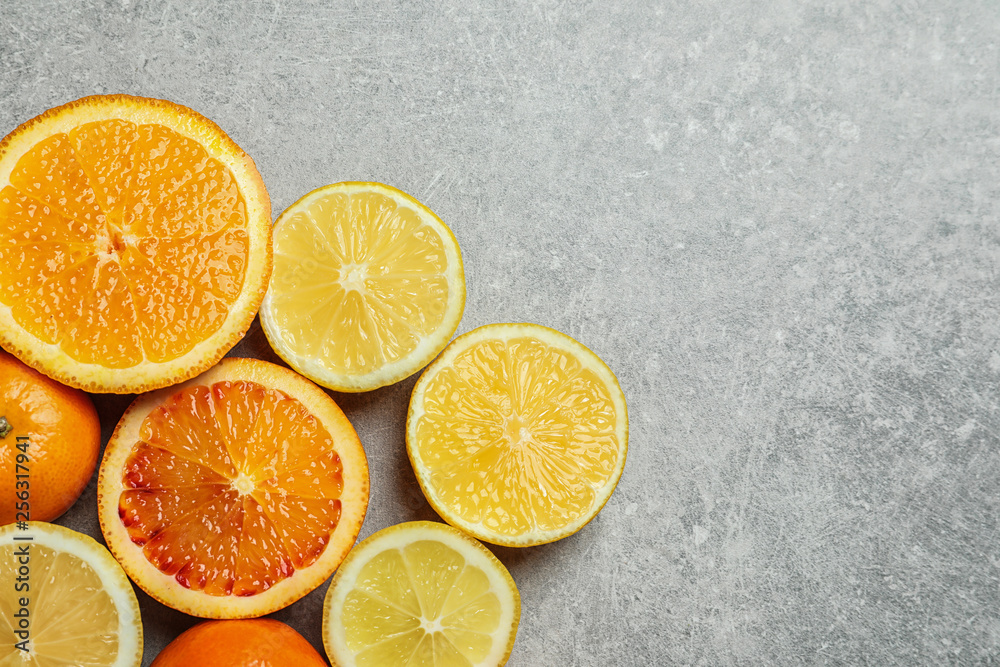 Different citrus fruits on grey background, flat lay. Space for text Different citrus fruits on grey background, flat lay. Space for text