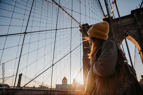 USA, New York, New York City, female tourist on Brooklyn Bridge at sunrise photo