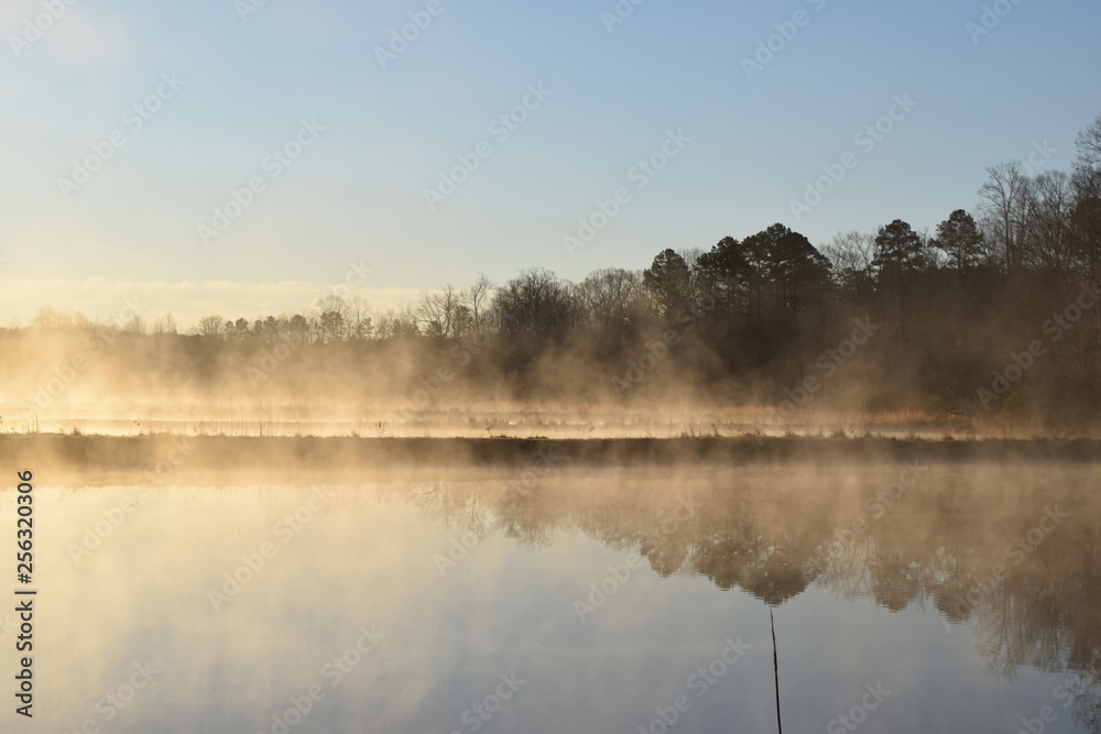 Steam fog rises over ponds on a cold spring morning in Mississippi