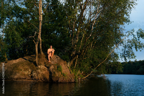 Man sitting on an island in a lake