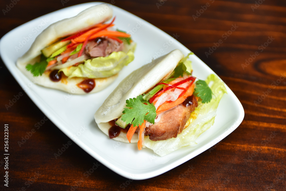 Fresh delicious pork steamed buns with BBQ sauce, coriander, mint, salad leaf and vegetalbles carrots, capsicum Fresh delicious pork steamed buns with BBQ sauce, coriander, mint, salad leaf and vegetalbles carrots, capsicum