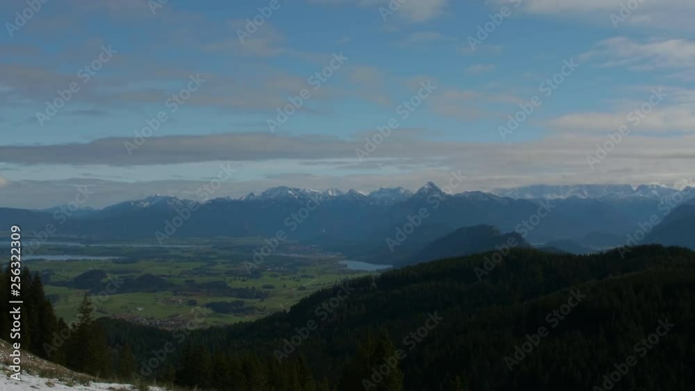 Panning horizon shot from ski lodge across to wide open Bavarian mountain range. Blue cloudy sky. Panning horizon shot from ski lodge across to wide open Bavarian mountain range. Blue cloudy sky.
