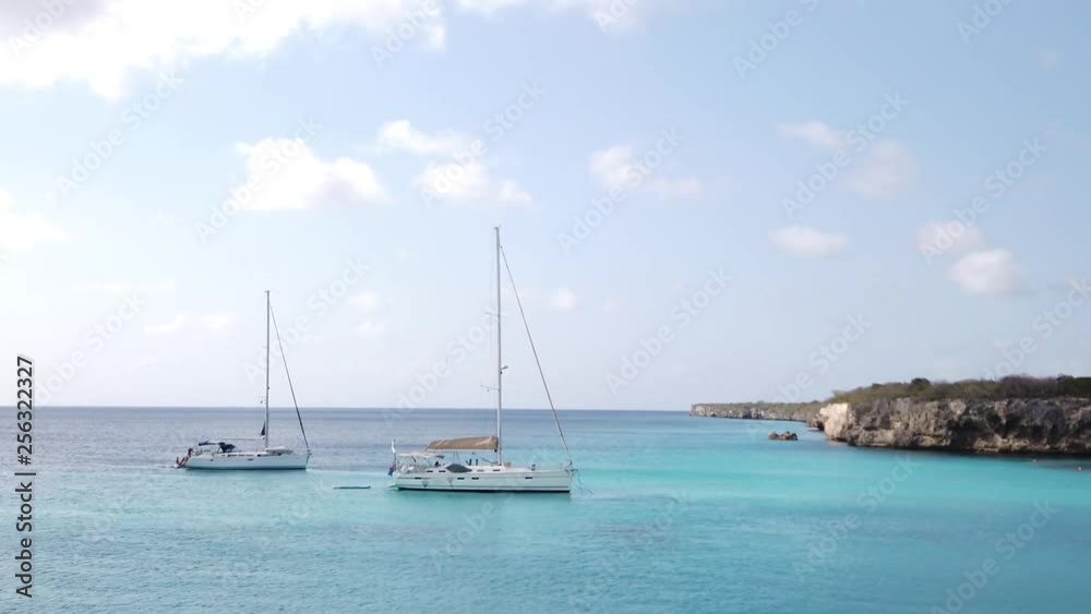 Sailboats at anchor in the famous Playa Kenepa Grandi aka Grote Knip beach bay in Curacao, sailing in the Caribbean sea, slow motion panning camera shot Sailboats at anchor in the famous Playa Kenepa Grandi aka Grote Knip beach bay in Curacao, sailing in the Caribbean sea, slow motion panning camera shot